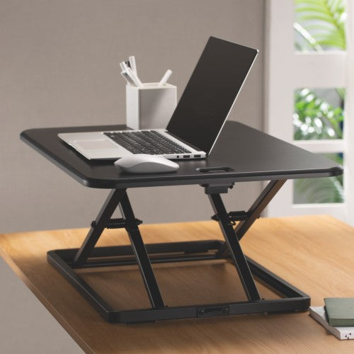 Ergox ultra-slim desk converter holding a laptop on a timber desk